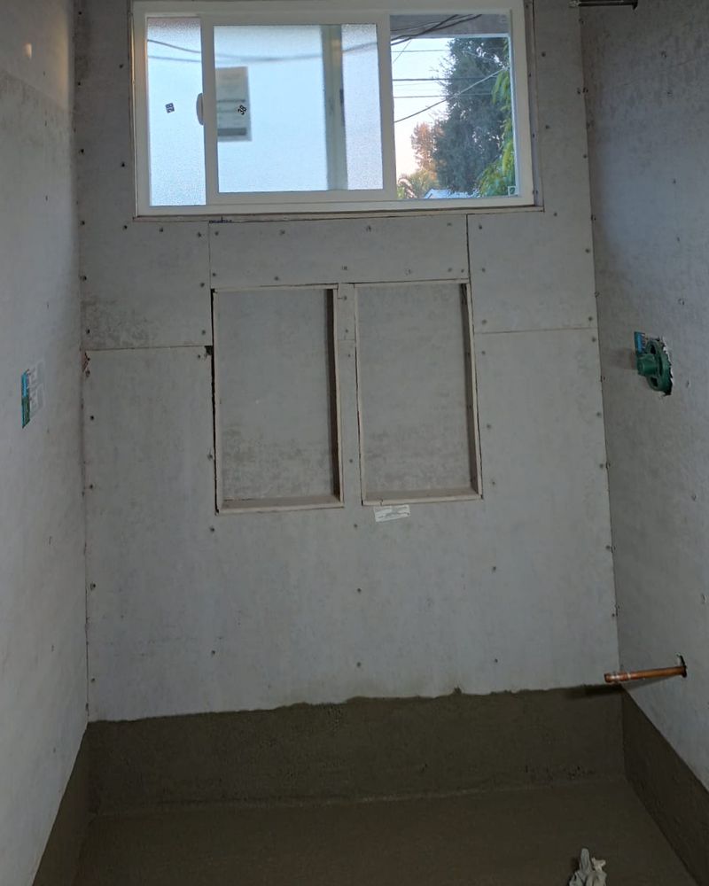 Shower with backer board walls, two framed niche openings, and a fresh mortar bed