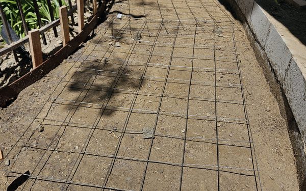 Curved walkway ready for concrete, with wire mesh tied out over compacted grade between timber forms