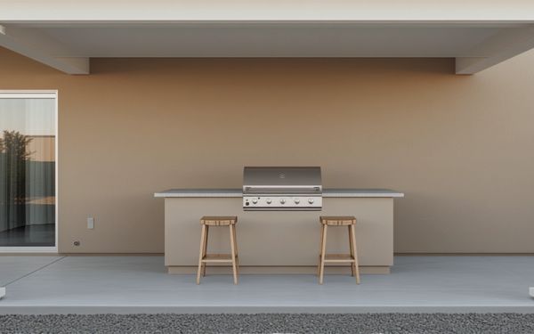 Design rendering of a covered patio with a tan stucco outdoor kitchen counter against the house wall, a built in stainless grill with a closed lid, two wood bar stools, a sliding glass door at the left, and a light gray concrete floor