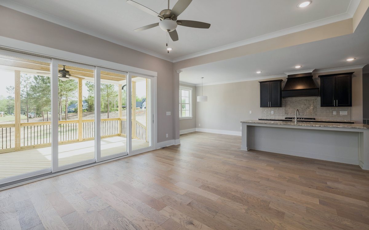 Wide plank wood flooring running through an open living area into the kitchen