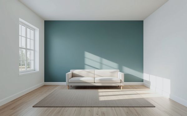 Design rendering of a living room with a muted blue green accent wall behind a white sofa, soft white side walls and ceiling, a rug, and a light wood look plank floor