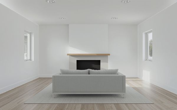 Design rendering of a family room with a white plaster fireplace wall running from floor to ceiling, a wood mantel shelf, a dark fireplace opening, a light gray sofa on a rug, and a light wood look plank floor
